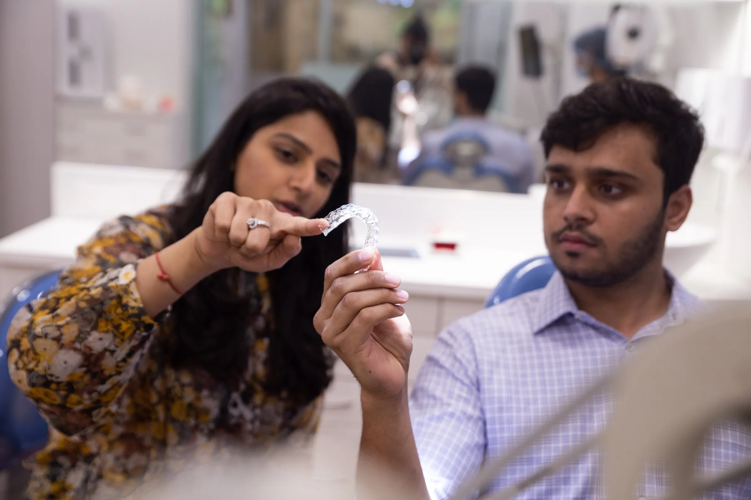 Dr. Upasana showing a clear aligner to a patient