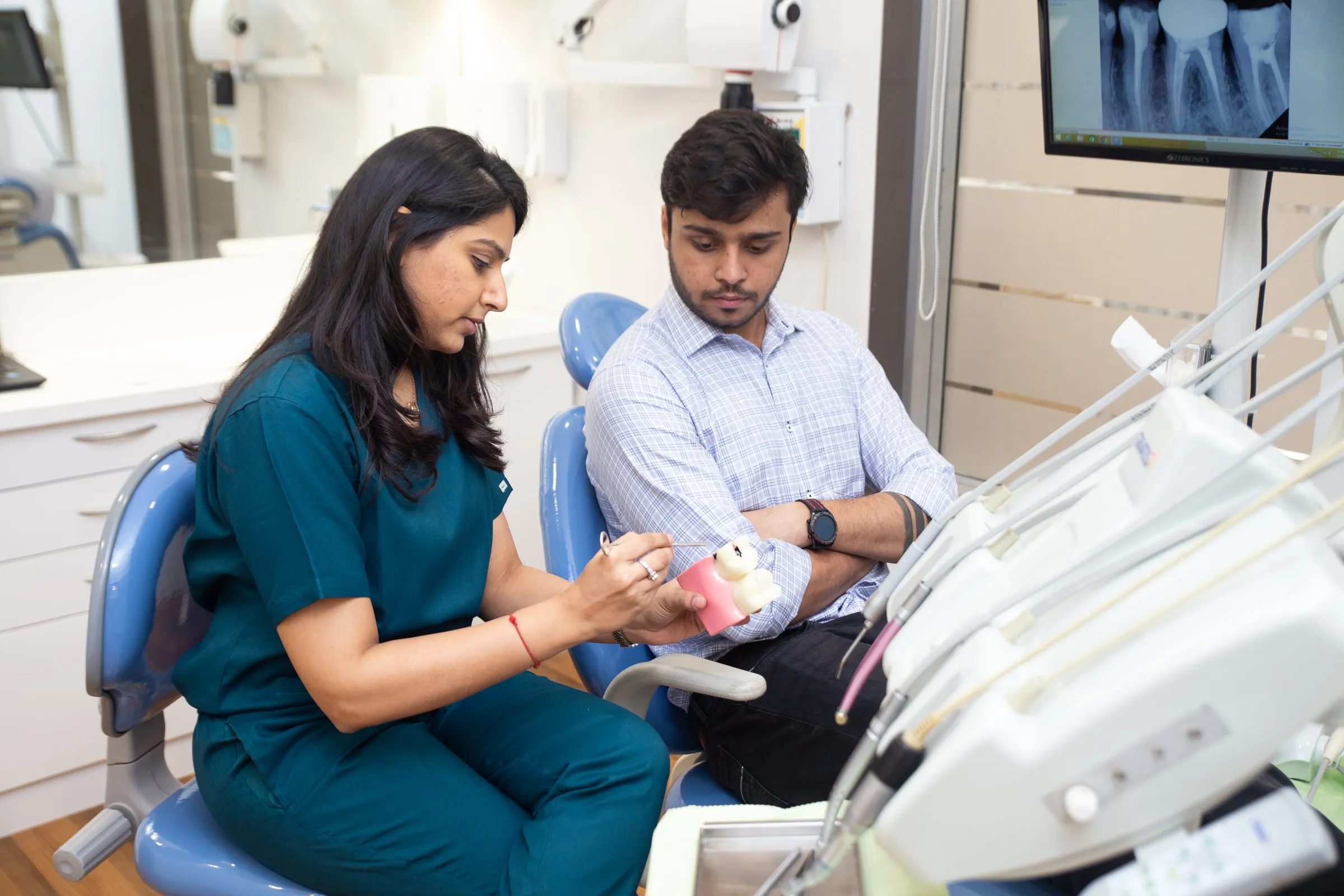 Dr. Upasana explaining treatment with a dental model